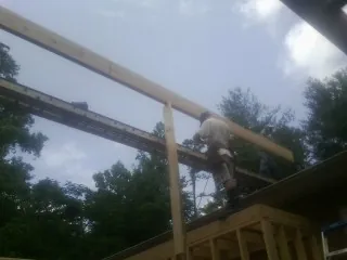 Carpenter setting a ridge beam over a new addition frame — Ice Dam Removal by Roofing Brothers in East Setauket