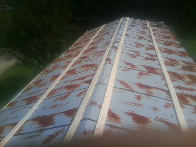 Rusted metal roof panels with new wood purlins before replacement — Storm Damage Roof Repair in East Setauket by Roofing Brothers