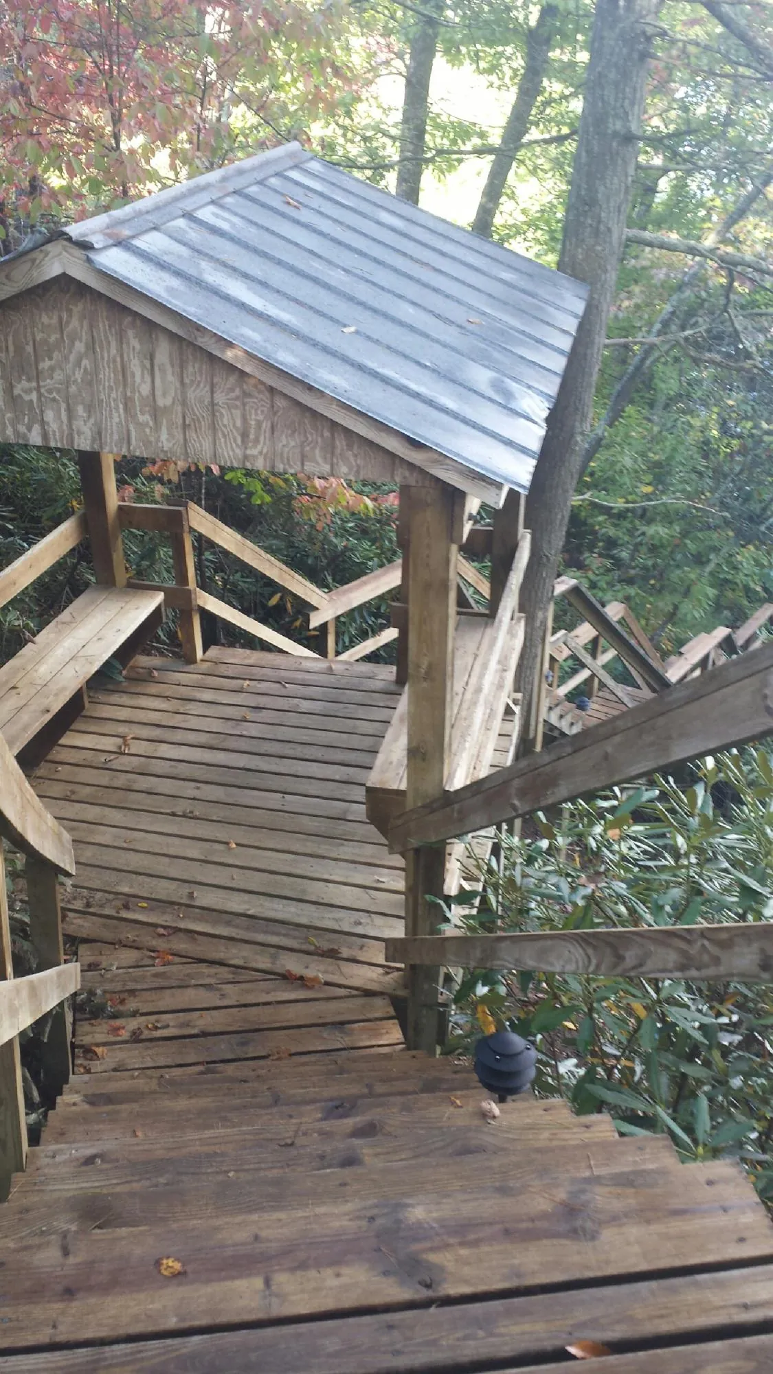 Metal roofed shelter over wooden steps on a wooded walkway — Skylight Repair & Installation work by our crew in East Setauket