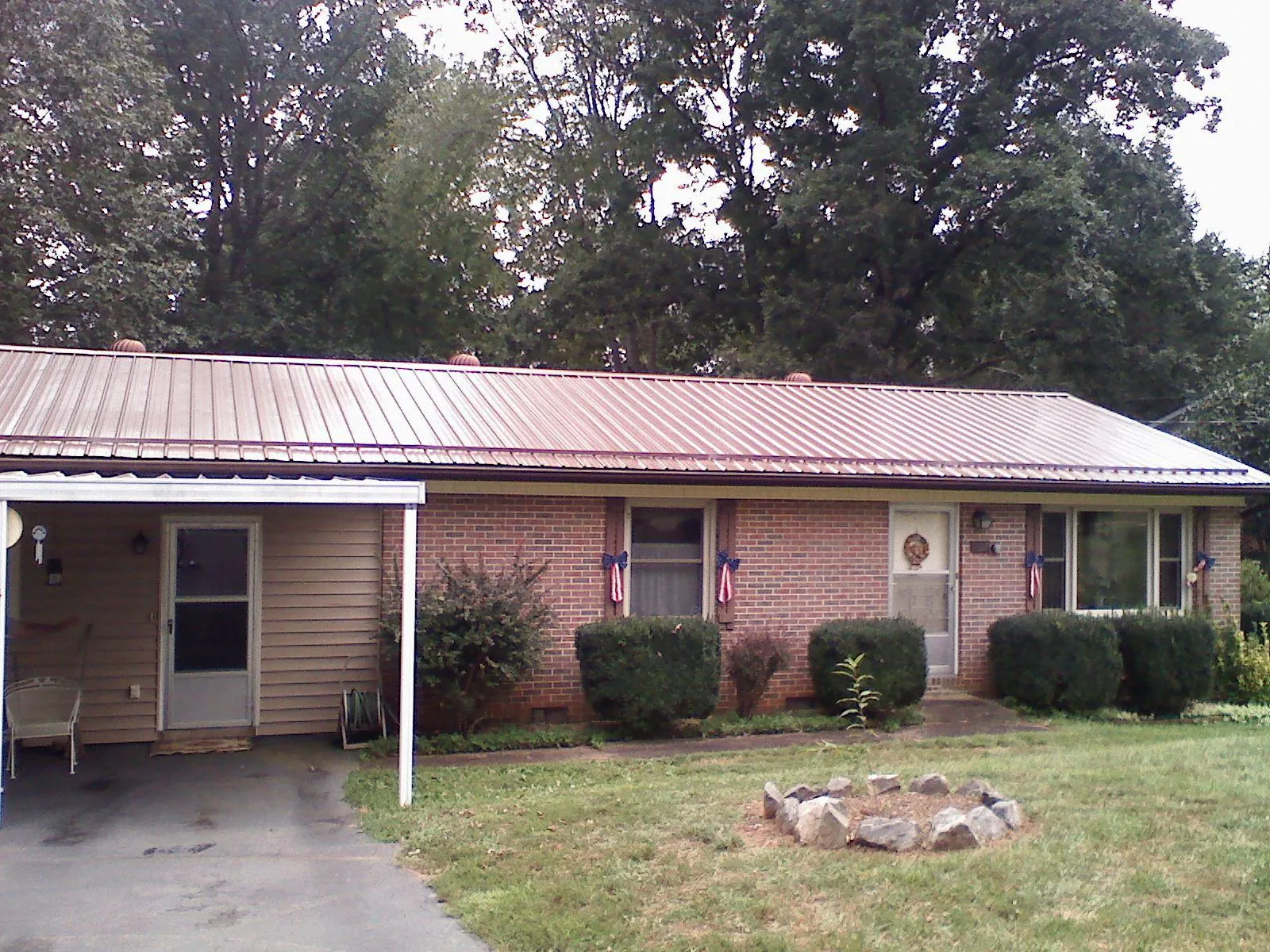 Bronze metal roof and carport on a brick ranch home — Roof Repair work by our crew in East Setauket